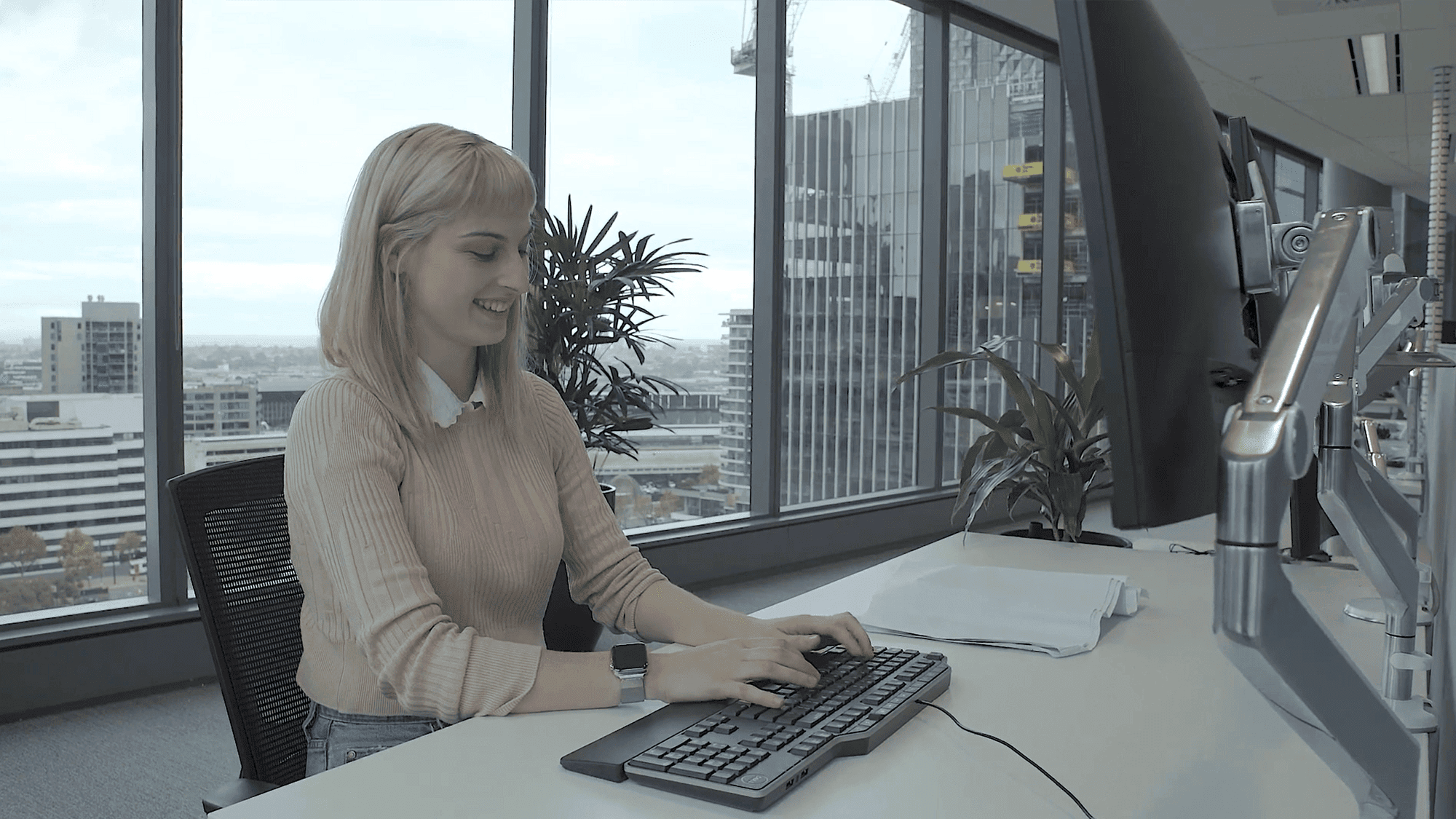 Woman sat at desk in high rise office building